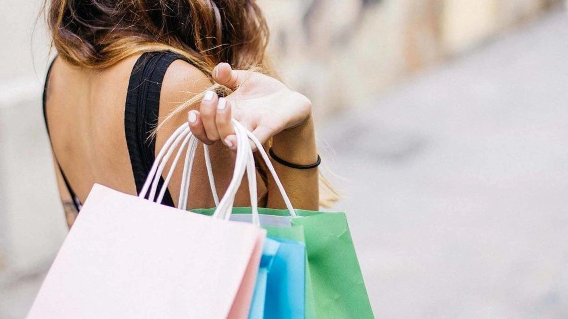 Woman with her back to camera, holding several shopping bags in her hand