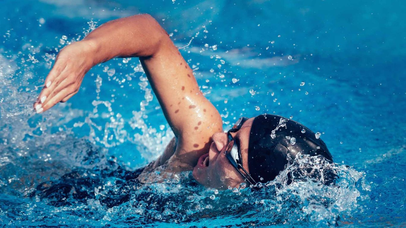 Swimmer in pool with goggles and swimming cap