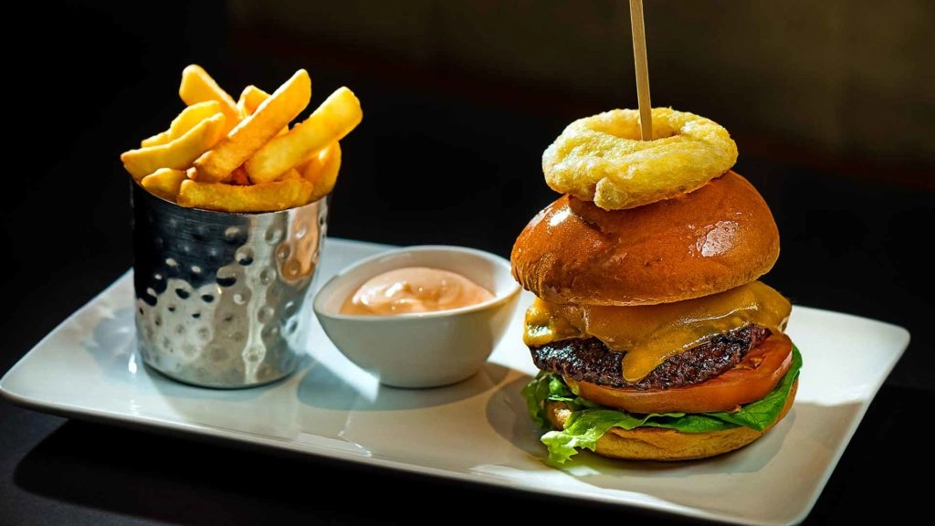 Burger and Chips Image of beef burger with onion rings, chips and dip